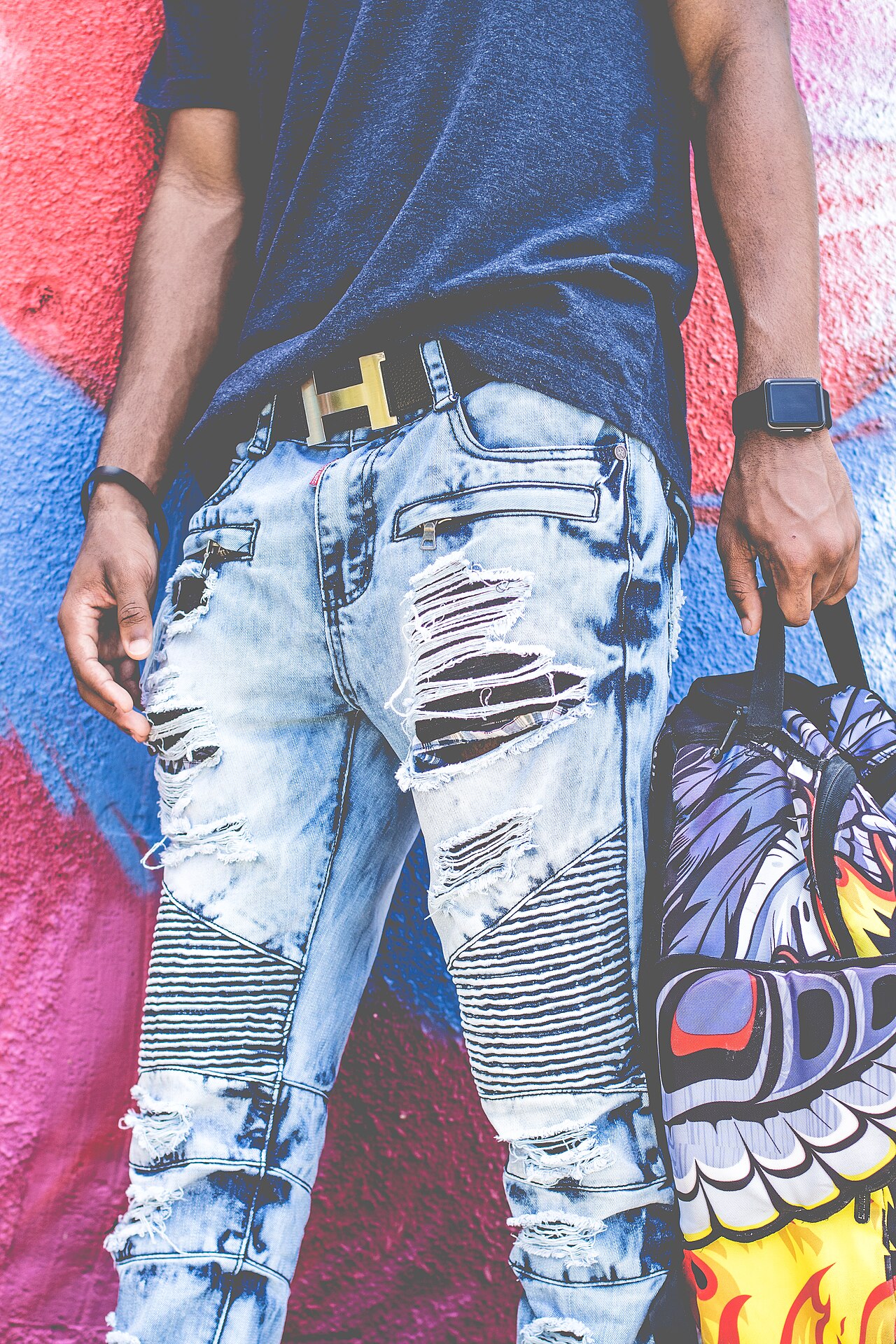 A stylish woman with perfectly styled hair walks past a vibrant street art mural in Wynwood, Miami.